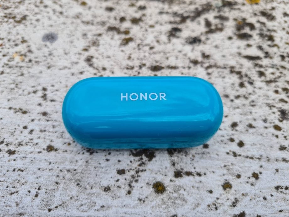 Blue Honor Magic earbud's case kept on a concrete floor