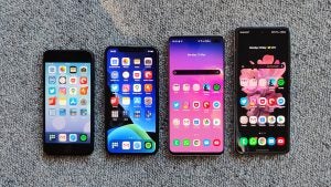View from top of an iPhone SE, an iPhone 11 Pro, a Samsung S10 plus and a Samsung flip laid on a carpet