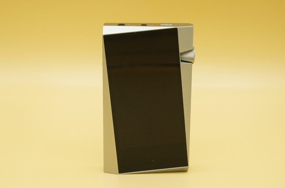 A black and silver AK SR25 music player standing on yellow background