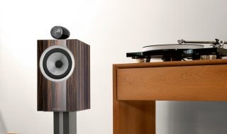 A brown-black BW702 signature speaker standing on stand