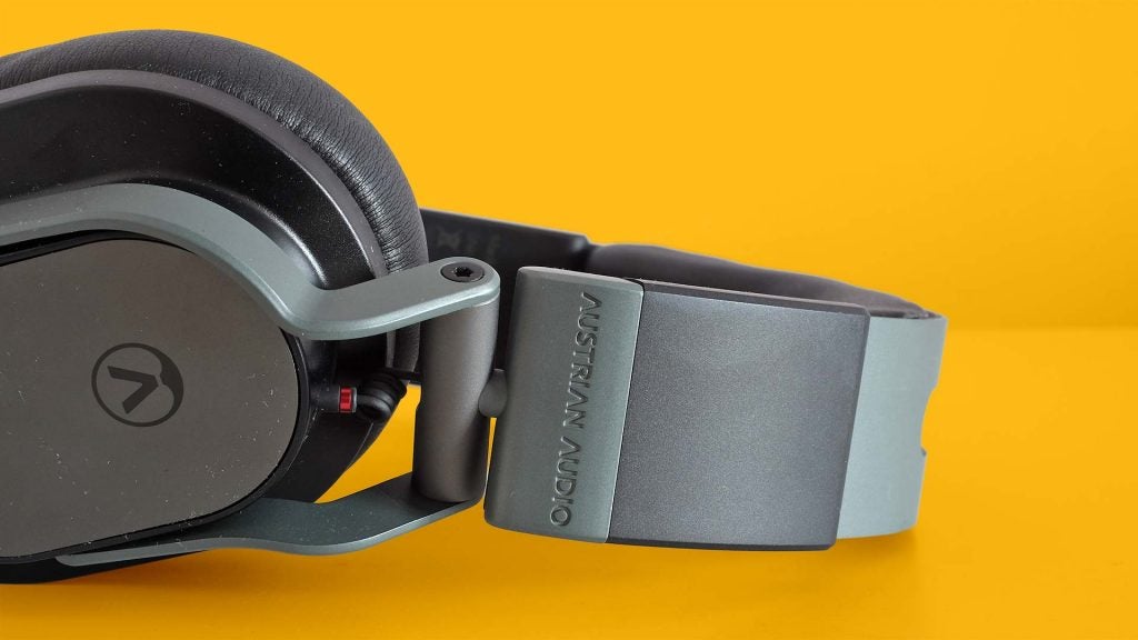 Austrian Audio Hi-X55Close up image of gray-black Hi-X55 headphone's headband resting on a solid-yellow background