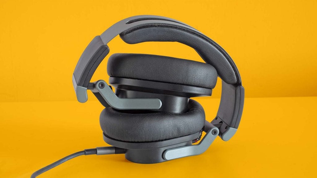 Austrian Audio Hi-X55Folded gray-black Hi-X55 headphones standing on a solid-yellow background