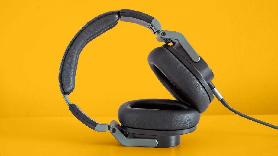 Gray-black Hi-X55 headphones standing on a solid-yellow background