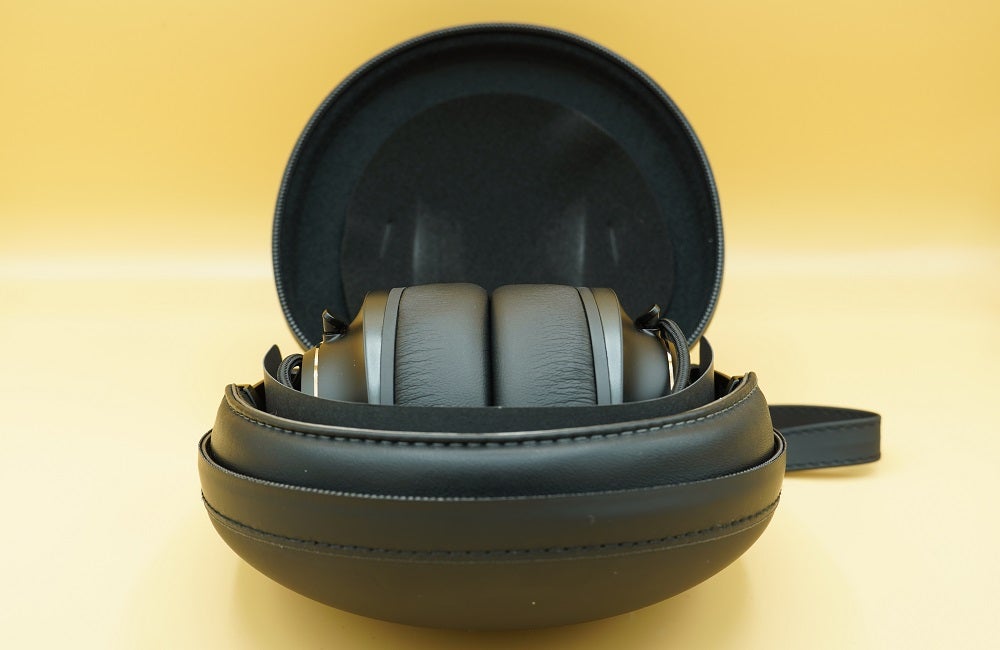 Black JBL Club One headphones resting in it's case on a table