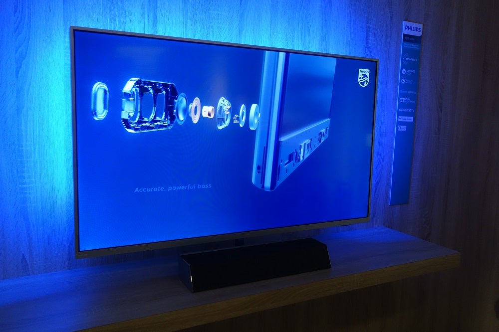 A black Philips 9235 TV standing on a shelf displaying a blue wallpaper