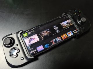 A black Razer Kishi gaming controller fitted on a smartphone resting on a table