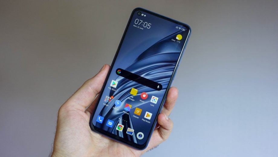 A Remi Note 9 held in hand displaying homescreen