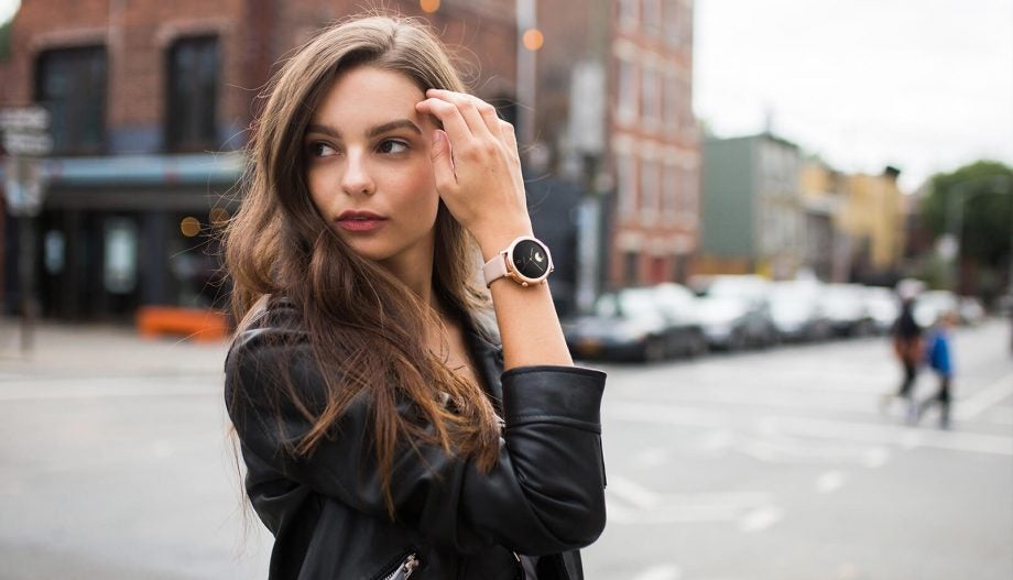A women in black outfit wearing a TicWatch C2 standing in street