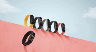 Five different colored Xiaomi Mi band 5 standing on a wall and a falling down