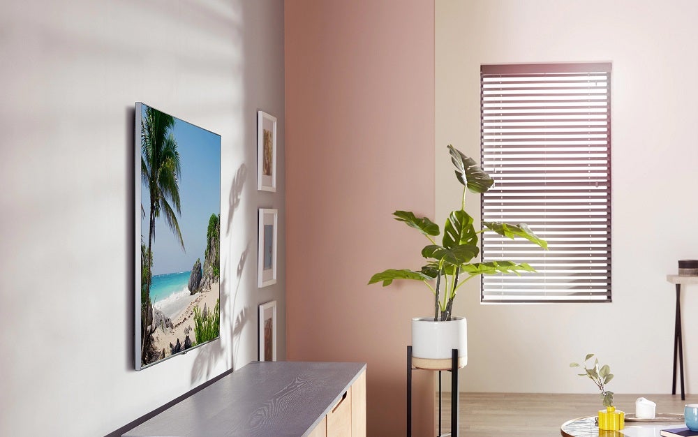 A silver Samsung TU8500 TV fixed on a white wall