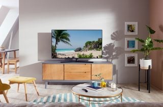 A black Samsung TU8500 TV standing on a shelf in a living room