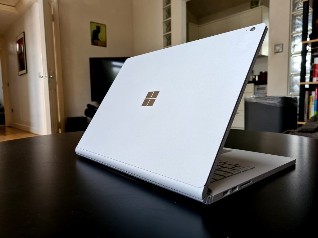 Back right view of a white Surface Book 3 standing on a table