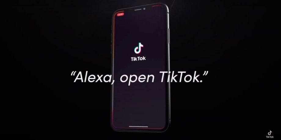 A smartphone standing on black background displaying wallpaper of TikTok with Alex Open TikTok written on top