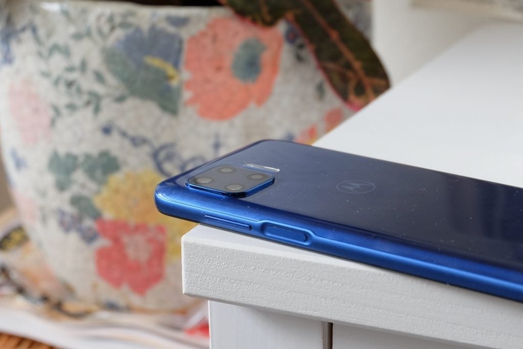 A blue Motorola G 5G plus laid upside down on a white table