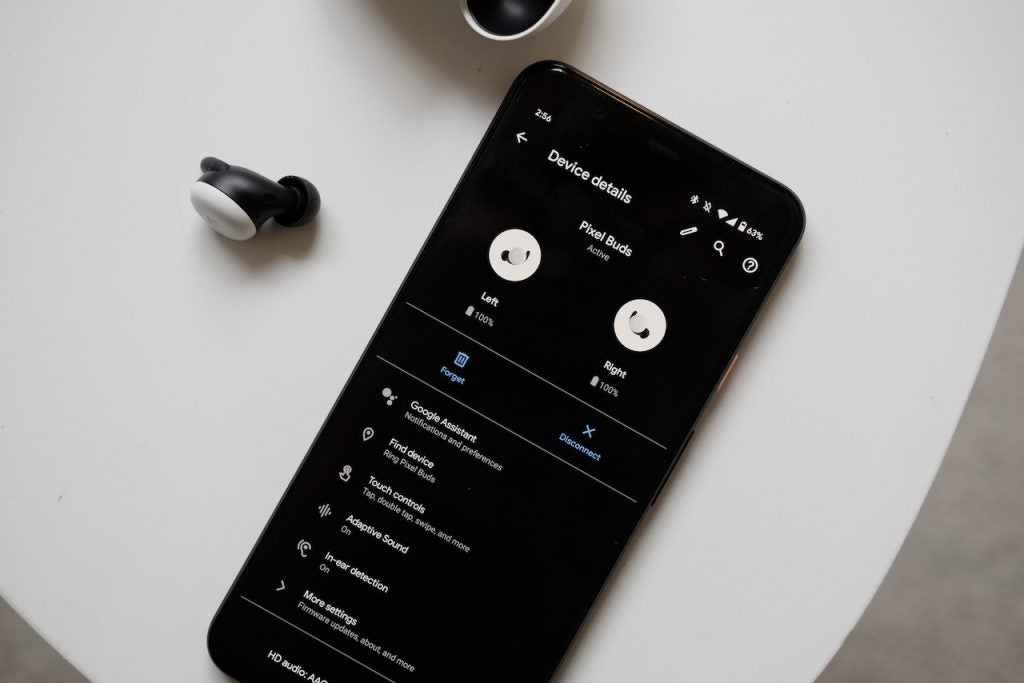 View from top of a smartphone displaying Pixel Buds device details with Pixel buds resting beside