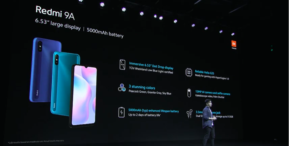 Xiaomi Redmi 9A man standing on a stage and Redmi 9A smartphone with its specs dispalyed on the screen behind