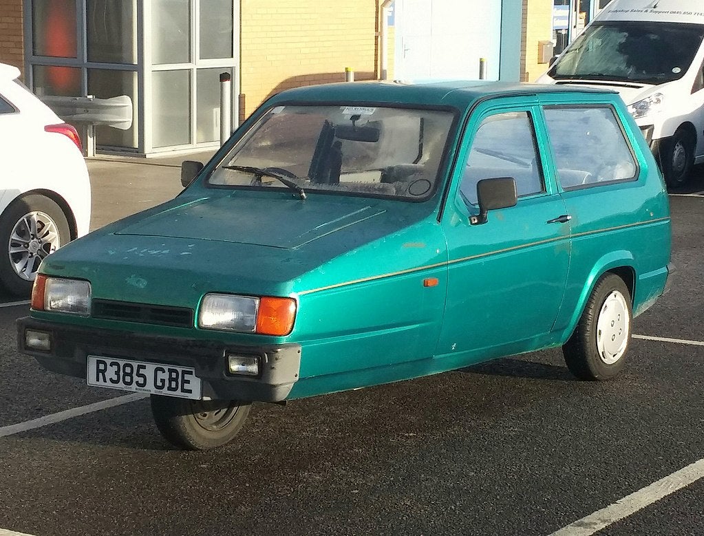 A green reliant Robin car from 1998 with three tyres