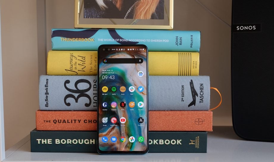 A smartphones standing against a tower of books