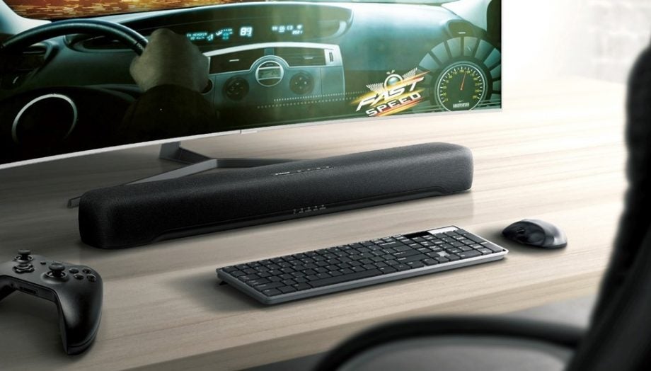 A black Yamaha C20 soundbar kept on a table in front of a monitor