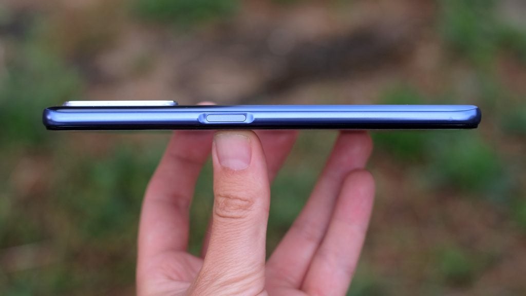 Right side edge view of a Realme X50 smartphone held in hand