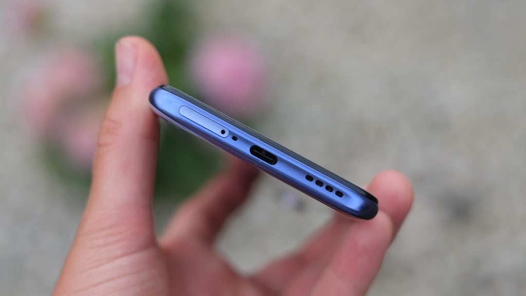Bottom edge view of Realme X50 smartphone held in hand