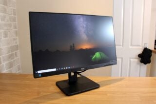 Left angled view of a black AOC 24 monitor standing on a wooden table