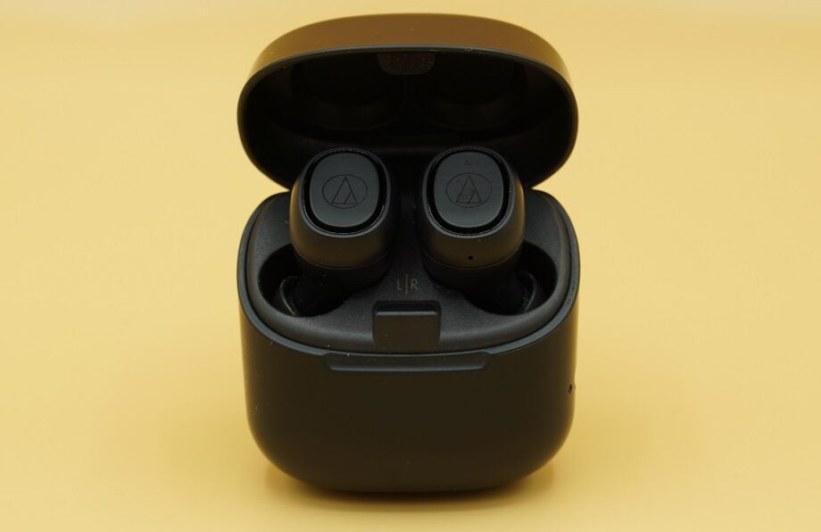 Black Technica ATH CK3TW earbuds resting in it's black case