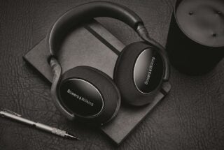 View from top of gray-black Bowers and Wilkins PX7 headphones resting on black background