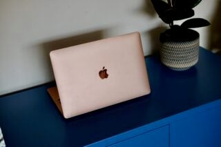 Back left view of back panel of a pinkish cream colored Macbook Air