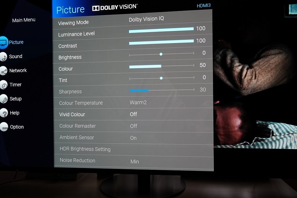 TV hitam berdiri di atas meja yang menampilkan pengaturan Dolby Vision IQ di bawah menu gambar