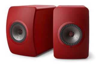 Right angled view of two brownish red KEF LS50 speakers standing on a white background