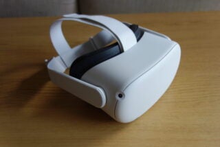 A white Oculus Quest 2 kept on a wooden table, back left view