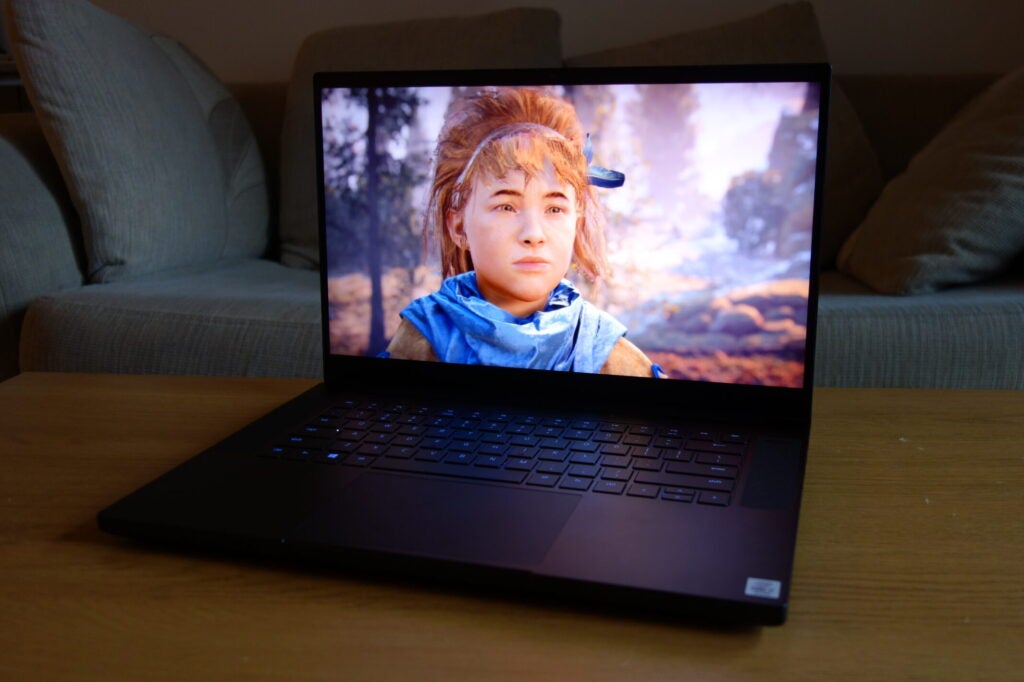 Razer Blade 15 2020Right angled view of a black Razer Blade 15 standing on a wooden table, displaying an animated picture of a girl