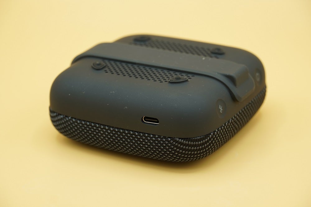 Left angled view of a black Tribit Stormbox Micro's back panel resting on a table