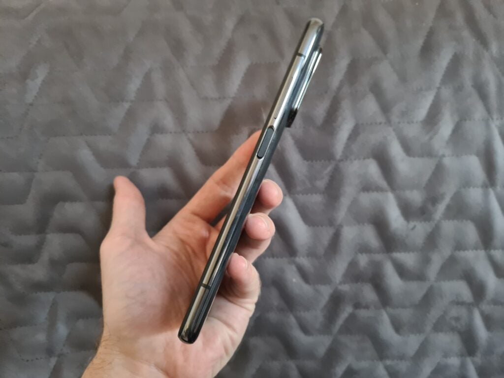 A black Xiaomi Mi 10T Pro smartphone's right edge view,  held in handA black Xiaomi Mi 10T Pro smartphone held in hand