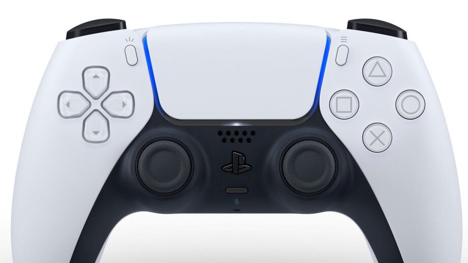 Close up image of a black and white PS controller standing on white background