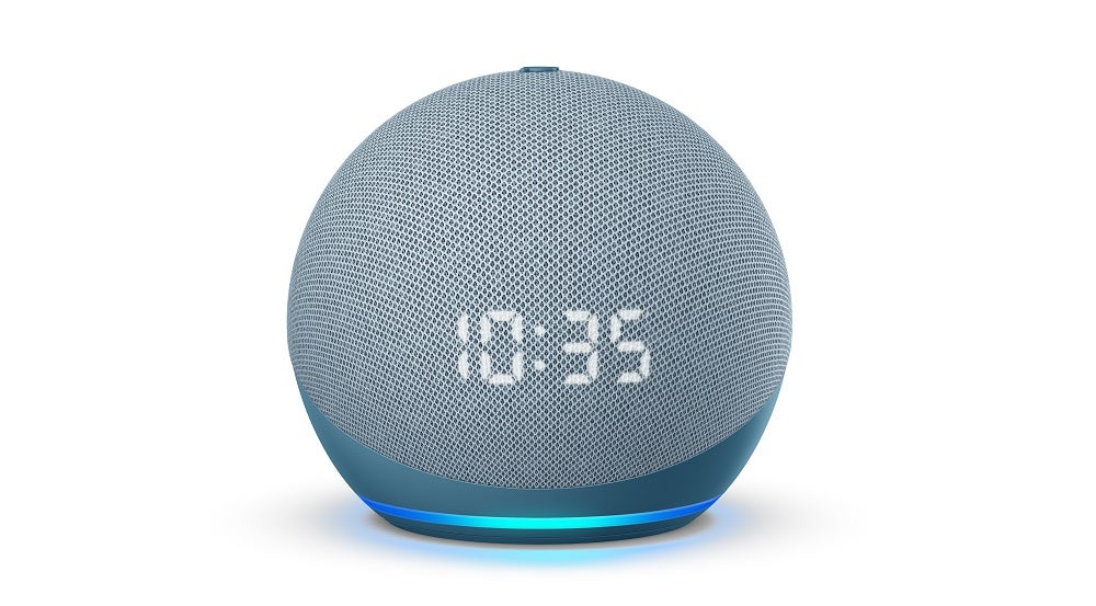 A blue-silver Amazon Echo Dot standing on a white background, displaying time on itself
