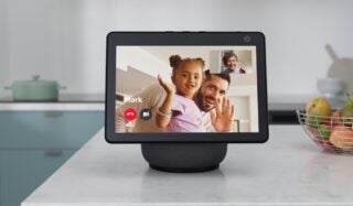 Front view of a gray Amazon Echo show 10 standing on a table, displaying live video call feed