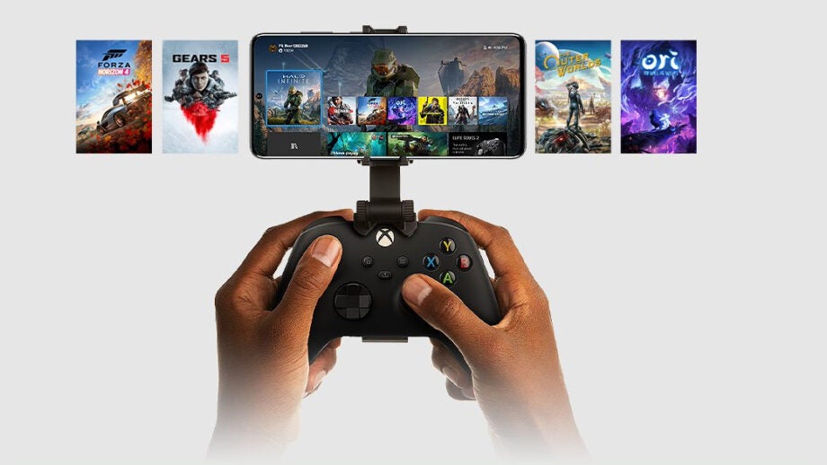 A black Xbox controller held in hand with a smartphone attached to it and games listed in and beside it