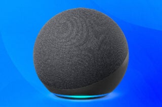A silver round Amazon Echo 4th gen speaker standing on blue background