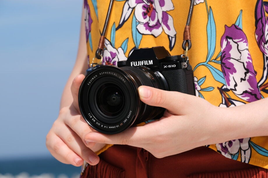 A black Fujifil camera held in hand