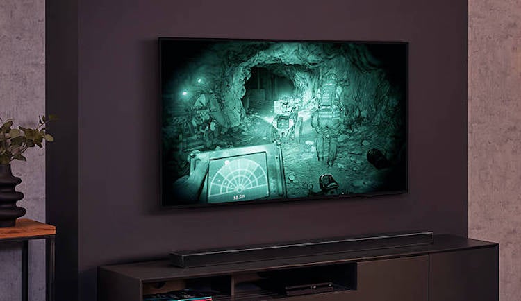 A black LG OLED 48 CX TV hanging to a wall 