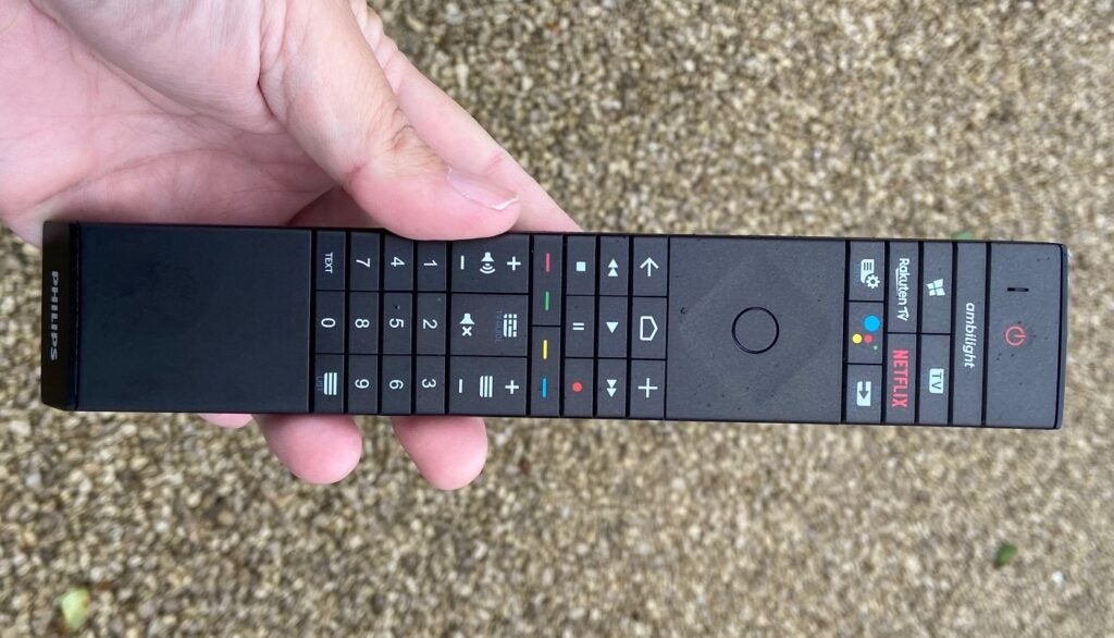 A black Phillips 65 OLED935's black remote held in hand