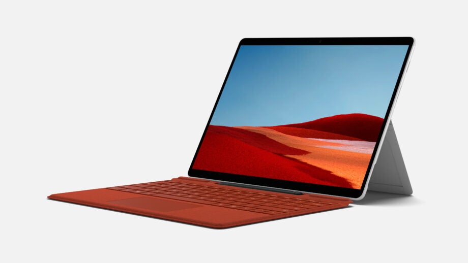 Right angled view of a silver-red Surface Pro X laptop standing on a white background