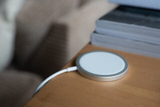 A white-silver disk connected to a white wire resting on a wooden table