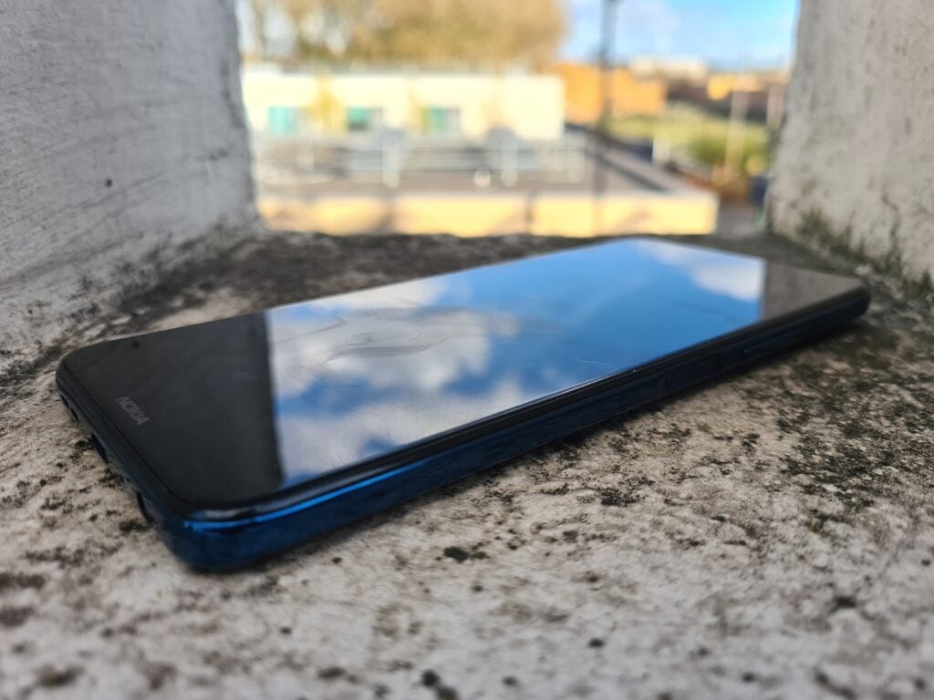 Close up right angled view of blue Nokia smartphone laid on a concrete block