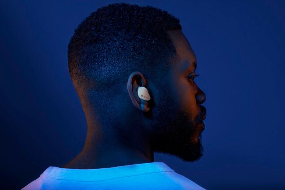A man facing back wearing white Cambridge Audio Melomania touch earbuds