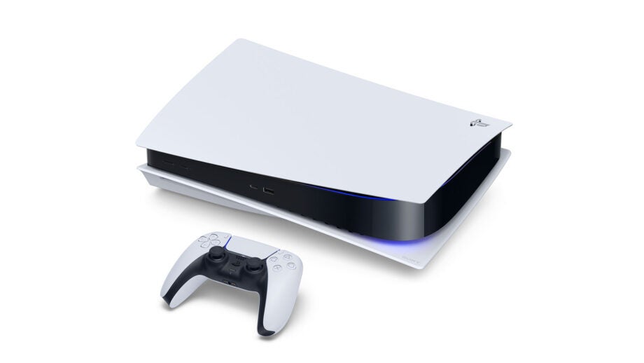 A PS5 laid on a white background with it's controller resting beside