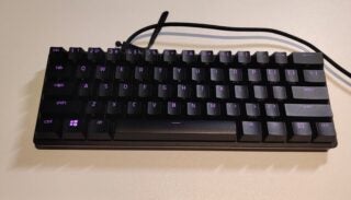 A black Huntsman mini keyboard resting on white background