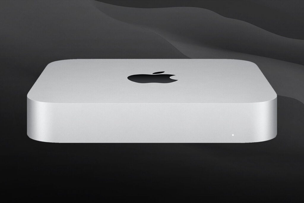 Front bottom side view of a white Mac mini resting on a black background